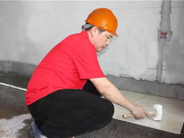 5鋪貼地磚時(shí)，磚的背面朝上批刮水泥油，并按箭頭所指方向統(tǒng)一鋪貼，用橡皮錘從中到邊，由重到輕敲實(shí).jpg